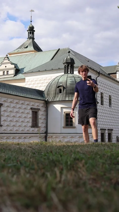 Vertical screen young traveler taking photos on smartphone near historic Europea Stock Footage 315413777