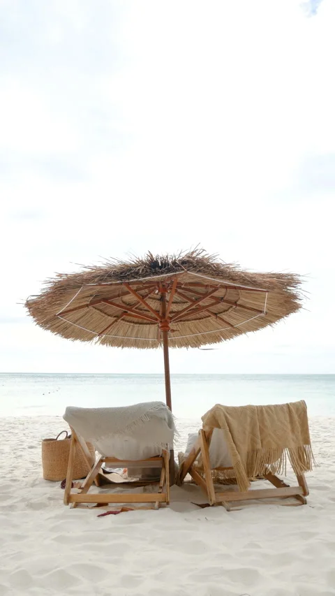 Vertical sea view white sand beach with two beach chair and thatched umbrella Stock Footage 186943048
