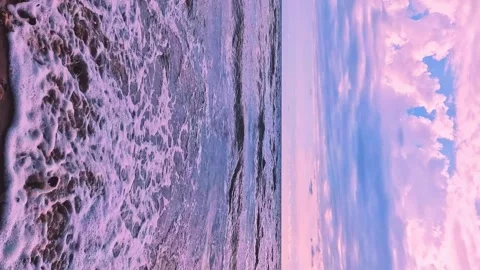 Vertical, sea waves sand and soft puffy lilac pink clouds in beautiful sunrise b Stock Footage 297464650