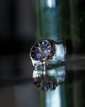 Vertical selective closeup shot of a gray and blue wristwatch 스톡 사진