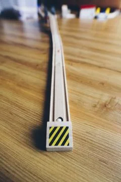 Vertical selective closeup shot of a racing car toy track on a wooden surface Stock Photos