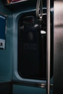 Vertical selective focus of a metal pole and bus handle captured in a train Photos