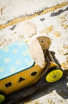 A vertical selective shot of a cute yellow and blue toy car with a carved she Foto stock