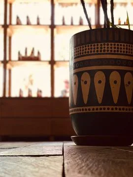 Vertical selective shot of painted patterns on a clay pot for plants on floor Stock Photos