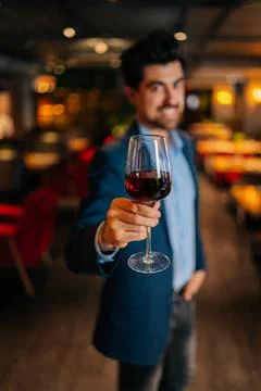 Vertical selective shot of positive elegant man in fashion suit holding glasses Stock Photos