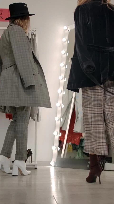 Vertical of Seller helping client to choose stylish outfit in light modern Stock Footage 276924939