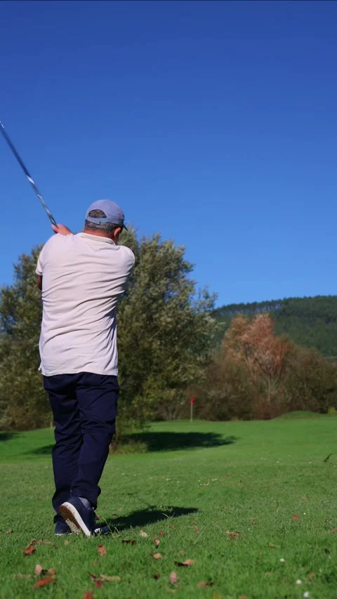 Vertical senior golfer making a shot towards the green during a competition.. Stock Footage 292017478