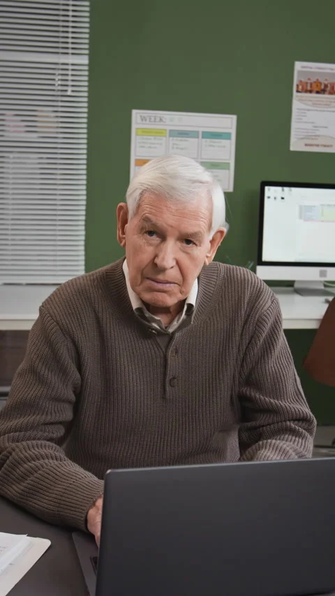 Vertical of Senior Man Looking at Camera by Laptop in Computer Class Stock Footage 333708669