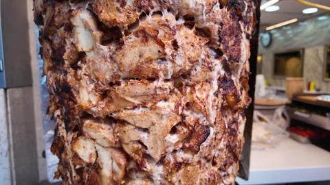 Vertical Shawarma Doner Kebab Cone Rotating on Spit in Busy Restaurant Kitchen 스톡 동영상 332827414