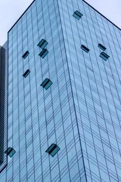 Vertical shoot of blue colored high-rise building with glass facade Stock Photos