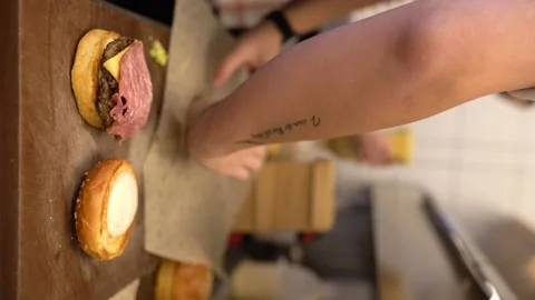 Vertical Shoot : Chef prepares and packs bacon burgers Stock Footage 196197661