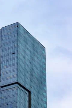 Vertical shoot of clear of blue colored high-rise building with glass facade Stock Photos