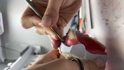 Vertical shooting, a dental technician makes a removable denture Stock Footage 262059411