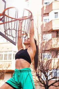 Vertical shot about a brown-haired Caucasian basketball player hangs herself  库存照片