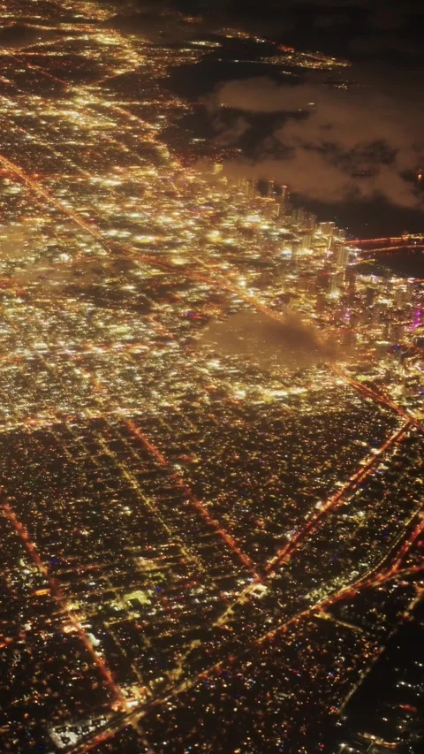 Vertical shot of airplane flying over Miami Beach Skyline illuminated at night Video stock 317828533