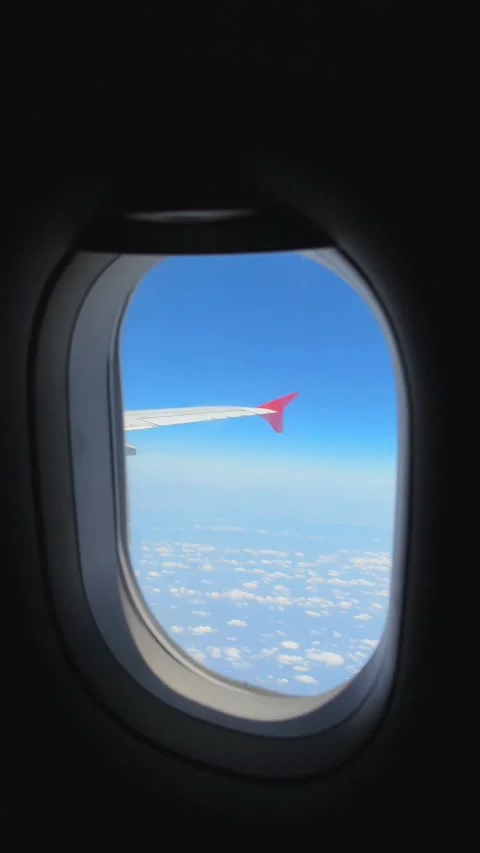 Vertical Shot of Airplane Window View Wing with Red Winglet and Clouds Stock Footage 341649777