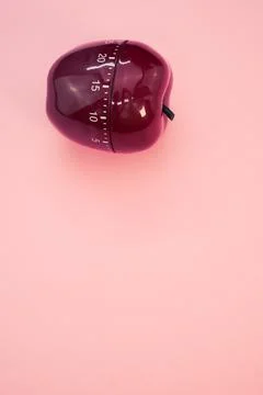 Vertical shot of an apple-shaped kitchen timer isolated on pink background 스톡 사진