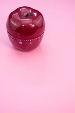 Vertical shot of an apple-shaped kitchen timer isolated on pink background 스톡 사진