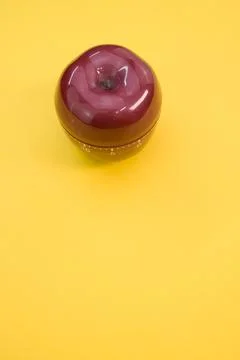 Vertical shot of an apple-shaped kitchen timer isolated on yellow background Stock Photos