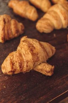 Vertical shot of an array of freshly baked, buttery croissants on a wooden table Stock Photos
