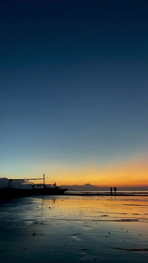 Vertical shot of beach dawn with sunbeams and couple silhouette Bali Video stock 343796810