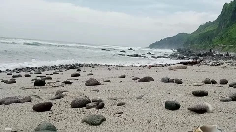 A vertical shot of a beach with a rock and a large stones Stock Footage 292262766