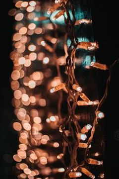 Vertical shot of beautiful string lights with bokeh lights in the background Stock Photos