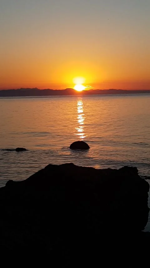 Vertical Shot of a Beautiful Sunset Over the Sea Coast 動画素材 337883435
