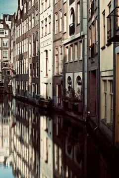 Vertical shot of the Binnenstad buildings reflecting in the water in Amsterdam, Stock Photos