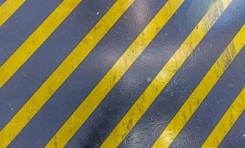 Vertical shot on a black ground surface with yellow hatching Stock-Fotos