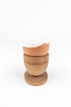 Vertical shot of broken egg shell in old wooden egg stand. Minimalism Stock Photos