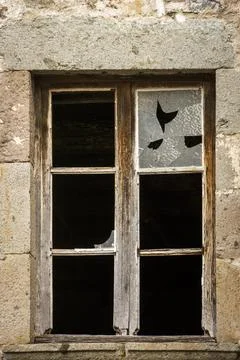 Vertical shot of a broken window in an old and abandoned house Stock Photos