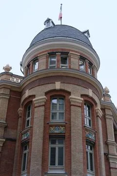 Vertical shot of a building with red bricks and glass windows in Paris, France 스톡 사진