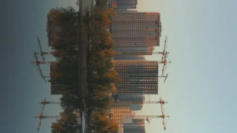Vertical shot of buildings construction site near water. Reflections on lake Stock Footage 203969064