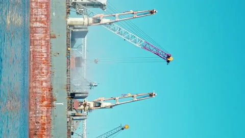 Vertical shot of Bunkering of dry cargo ship with grain with crane in seaport Stock Footage 228990453