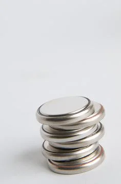 Vertical shot of button cell batteries on a plain background Stock Photos