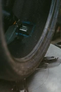Vertical shot of a car tire missing its rim with a radial patch being applied Stock Photos