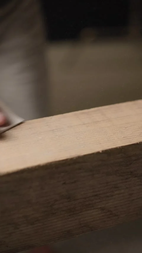 Vertical shot carpenter sanding raw wooden plank with sandpaper Stock Footage 344601382