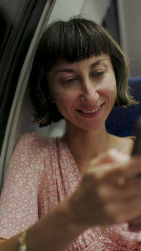 Vertical shot. Caucasian passenger sitting with smartphones in public transport. 動画素材 343716258