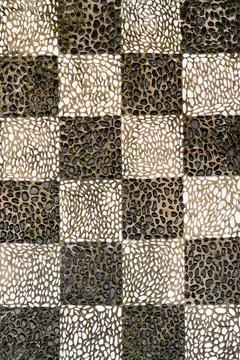 Vertical shot of a checkered pattern mosaic floor made of black and white pebble Stock Photos