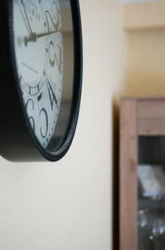 Vertical shot of a clock attached to a wall Stock Photos