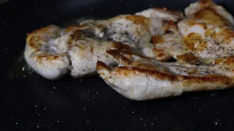 Vertical shot Close up of a grilled chicken breast on a black pan with olive oil 動画素材 142397965