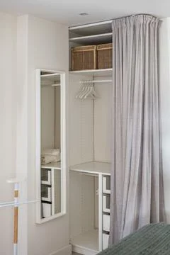 Vertical shot comfortable dressing room with gray curtain and storage space for Stock Photos