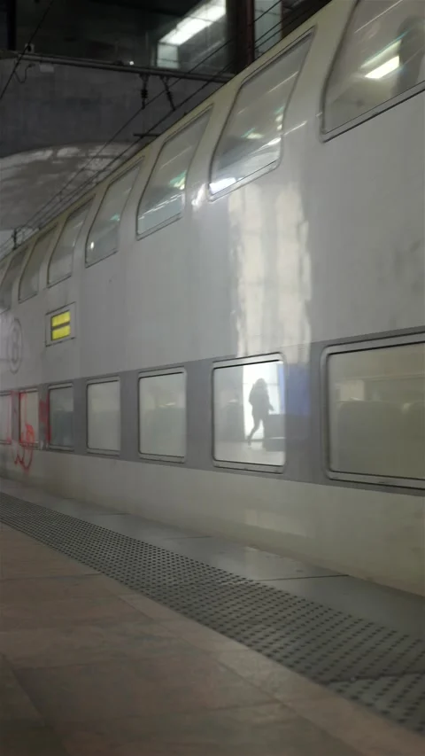 Vertical shot of commuter train leaving station on platform 動画素材 223139891