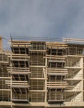 A vertical shot of the construction of a building with the dark sky in the ba Stock Illustration