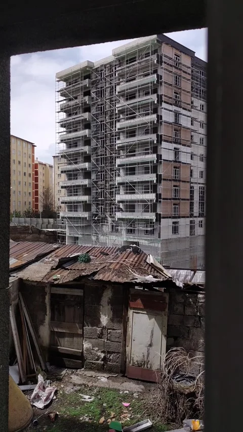Vertical shot of a construction foundation pit with steel bars, framed by a tree Stock-Footage 333524944