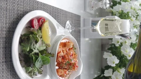 Vertical shot, The cook puts a dish of shrimp and fresh vegetables on the table Stock Footage 230563641