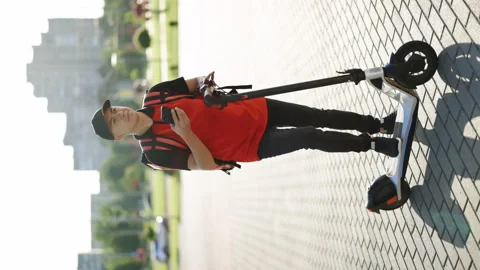 Vertical shot of courier man is looking for mobile phone to deliver address of Stock Footage 194605087