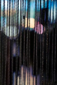 A vertical shot of decorative glitter string curtain with bokeh lights in the Stock Photos