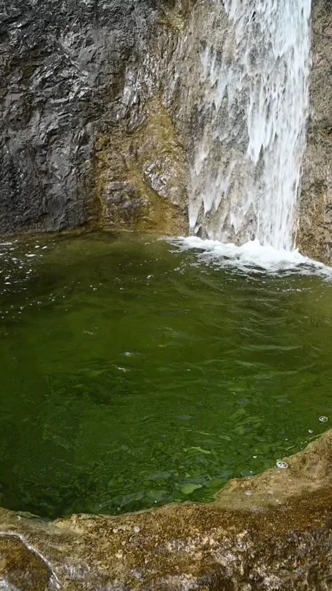 Vertical shot of the deep pond of a waterfall with green water, slow motion Stock-Footage 260888050
